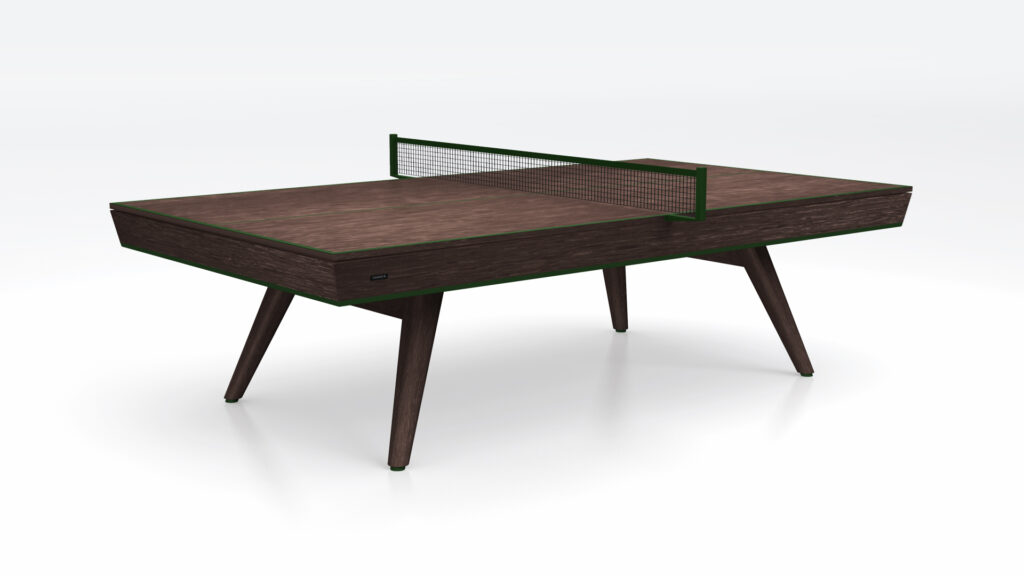 The Hamptons Ping Pong Table features a modern rectangular design with a dark wooden surface, angled legs, and a central net, shown against a plain white background.