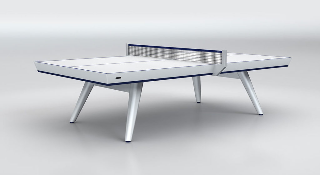 The Hamptons Ping Pong Table boasts a modern, sleek design with a minimalist look featuring a white surface, blue trim, and black net. It stands on four angular legs against a light gray backdrop, radiating elegance and style.