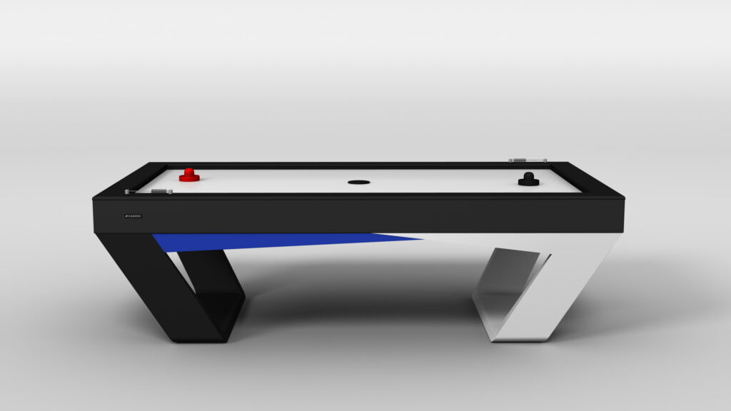 The Avettore Air Hockey Table features black and white angled legs, a sleek black frame with a blue accent, and comes with red and black strikers plus a puck on its white playing surface. Displayed against a plain white background.