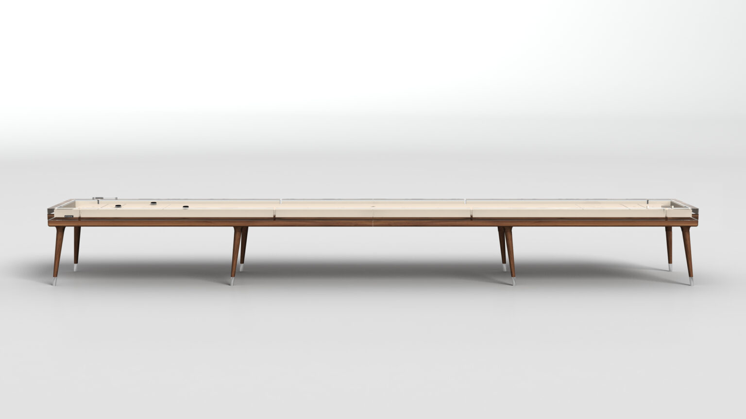 The Hamptons Shuffleboard Table features a long, modern design with a light wood playing surface, slim wooden legs, and clear protective sides, set against a plain white background.