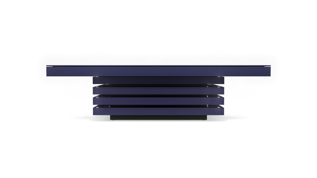 The Arclight Convertible Table, with its dark blue finish, exudes sleek elegance. Its flat top and four layered horizontal panels give it a floating look against a white backdrop.