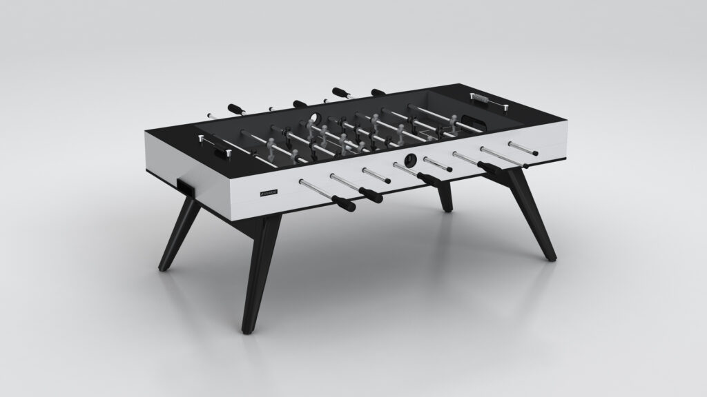 The Hamptons Foosball Table is a modern black and white design featuring angled legs and eight rods, shown against a plain light background.