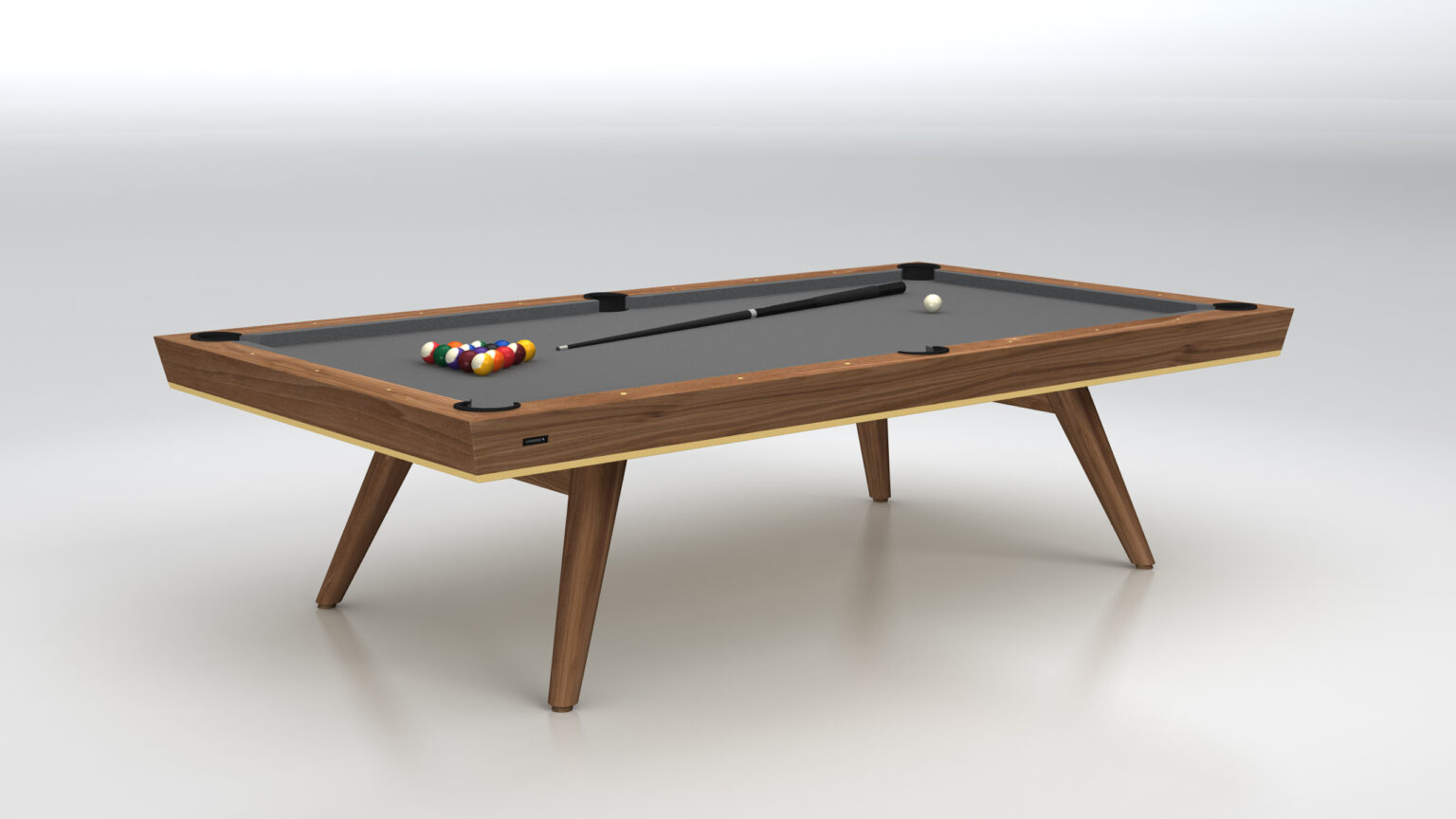 The Hamptons Pool Table, a luxury game table, showcases a sleek black surface with billiard balls neatly arranged at one end. A cue stick rests elegantly on the table, which stands on four angled legs against a plain white background.