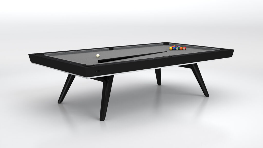 The Hamptons Pool Table, a luxurious black design with gray felt, features a cue stick and colorful billiard balls elegantly arranged on its surface, all set against a plain white backdrop.
