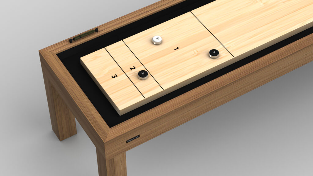 The Malibu Shuffleboard Table has a light wood playing surface with black scoring lines numbered 1 to 3 and includes three pucks—two black and one white—arranged on the board.