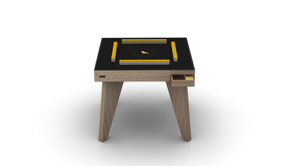 The Theseus Mahjong Table is a sleek, modern luxury game table with a black surface and a yellow and white digital interface. It features wooden legs and a small side drawer, all resting elegantly against a plain white background.