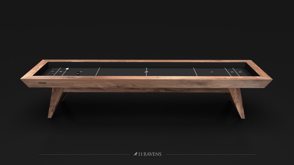The Trigon Shuffleboard Table is a modern, sleek piece with a wooden frame and black playing surface. It features multiple score zones and pucks, making it perfect for any refined game room.