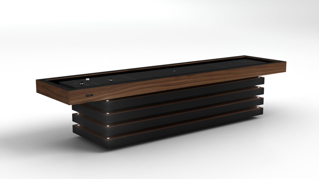 The Arclight Shuffleboard Table is a modern, rectangular table with a black top, wooden trim, and a base of horizontal black and wood slats, featuring minimalist controls and subtle lighting accents.