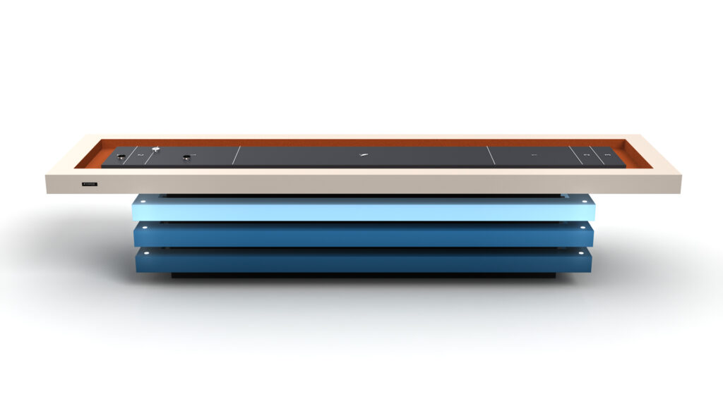 The Arclight Shuffleboard Table features a modern, minimalist design with a rectangular white frame, black tabletop, rust-colored interior edge, and stacked horizontal blue panels for support—a sleek and futuristic centerpiece.