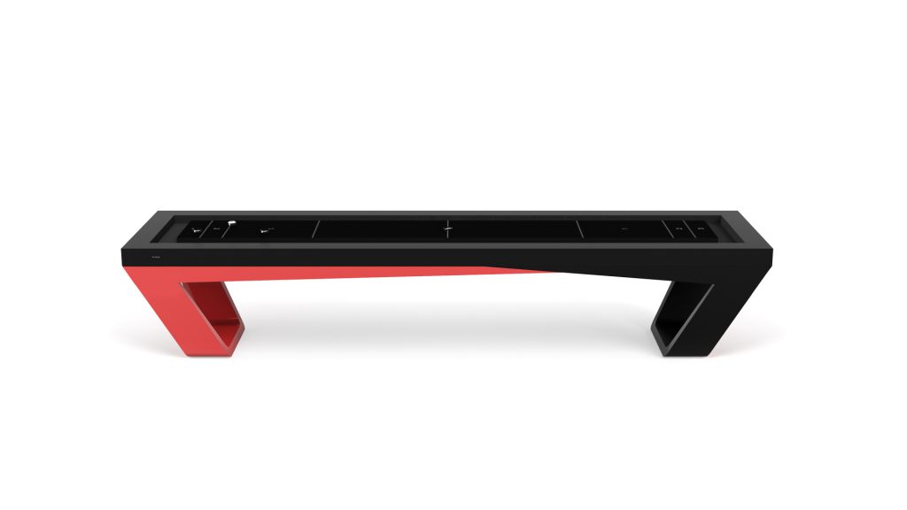 The bench, inspired by the Avettore Shuffleboard Table, boasts a modern geometric design with a sleek black top and leg, contrasted by a vibrant red leg on the opposite side. Its angular effect is strikingly set against a white background.