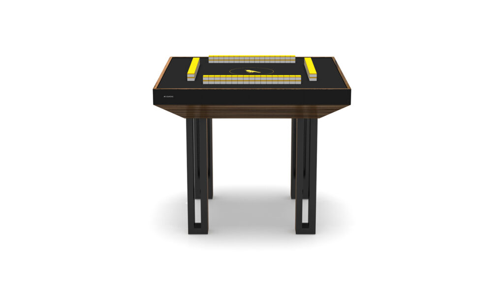 The Executive Mahjong Table features a sleek black design, four sturdy legs, and a central playing area with yellow and white tile patterns, shown against a white background.