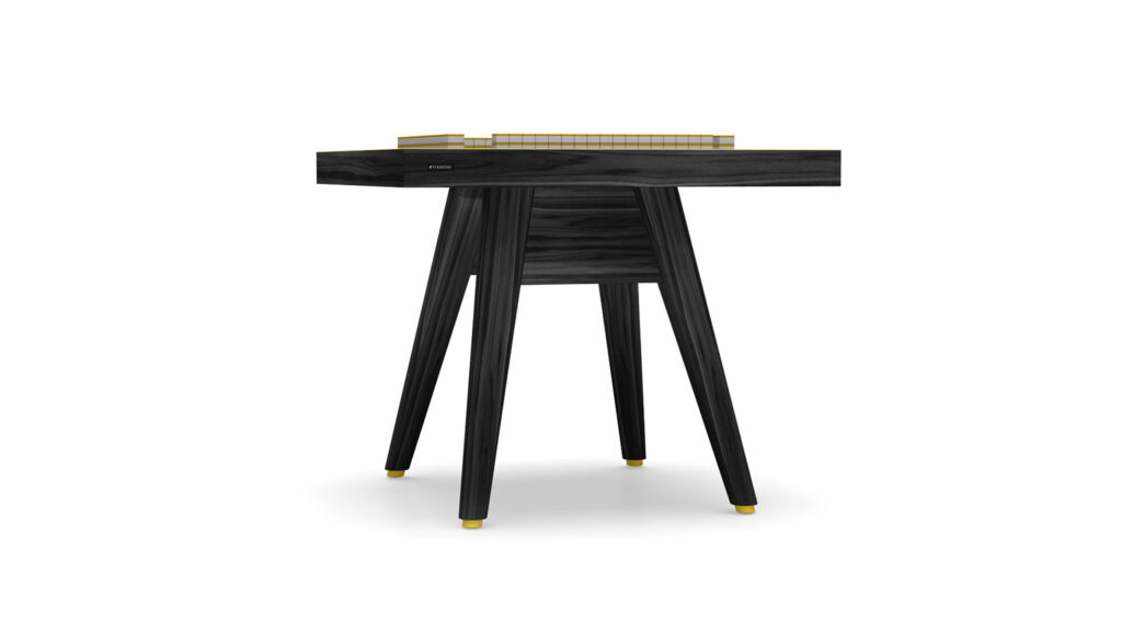 The Hamptons Mahjong Table is a modern black wooden chess table with four angled legs and gold accents on the feet and chessboard, inspired by luxury Hamptons design. Its sleek, minimalist style stands out against a white background.