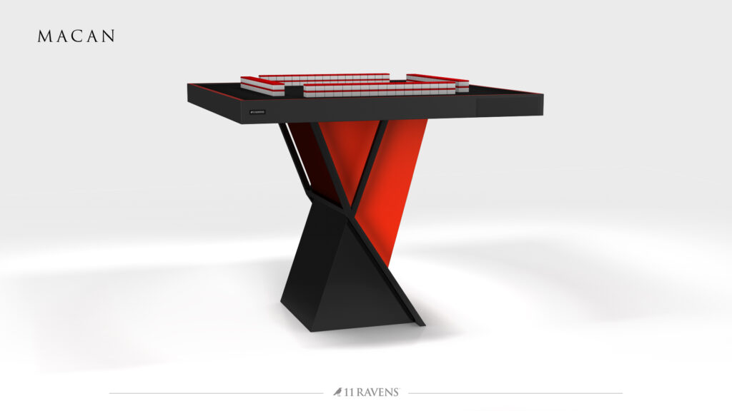 The Macan Mahjong Table showcases a bold, modern design with a black and red geometric X-shaped base and rectangular surface, set against a white background featuring the MACAN and 11 Ravens logos.