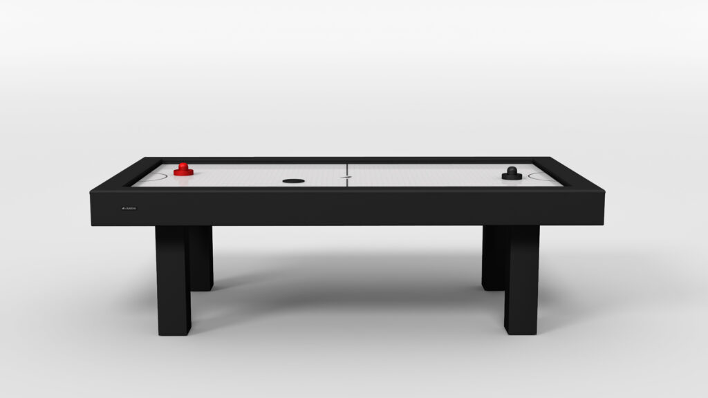 The Malibu Air Hockey Table features a sleek black frame, white playing surface, red paddle and puck on the left, black paddle and puck on the right, and stands firmly on four sturdy legs for lasting enjoyment.