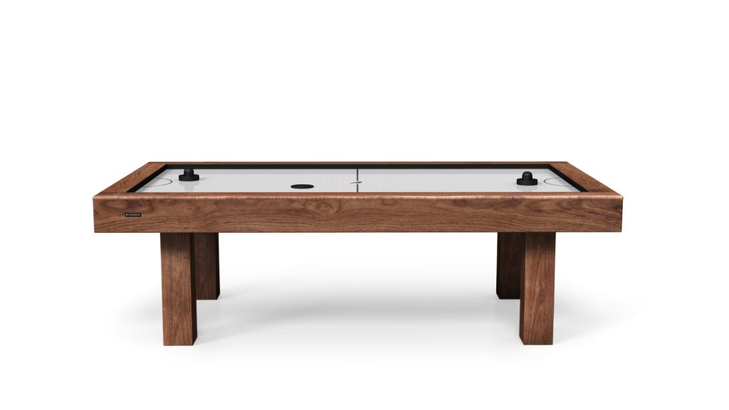 Presenting the Malibu Air Hockey Table, a sophisticated piece with a sleek wooden surface, accompanied by two black paddles and a puck. It stands elegantly on four solid legs, set against a simple white background.
