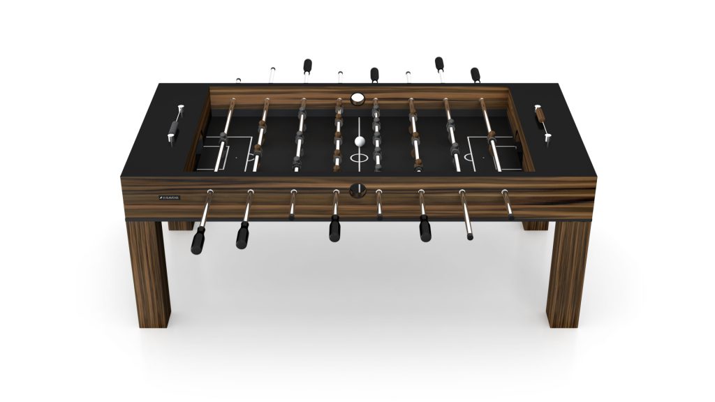 The Malibu Foosball Table features a sleek black playing field with a wooden design. Its rods, adorned with miniature soccer players, ensure an engaging game experience, while the minimalist white backdrop enhances its modern elegance.