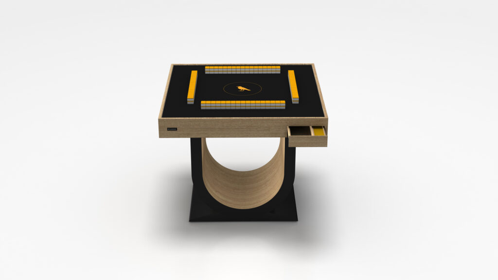 The Theseus Mahjong Table is a modern square luxury game table with a black surface, yellow tile central emblem and border, standing on a unique curved wooden pedestal. It features a small open drawer on one side.