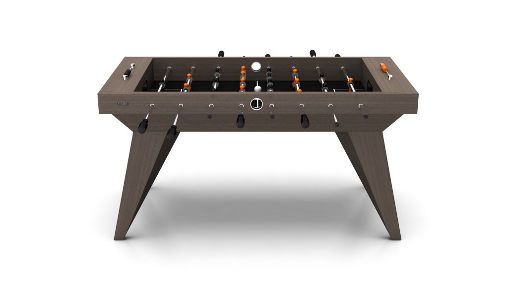 The Trigon Foosball Table features a sophisticated wooden finish and angular legs, with metal rods holding black and orange players on a white playing field.