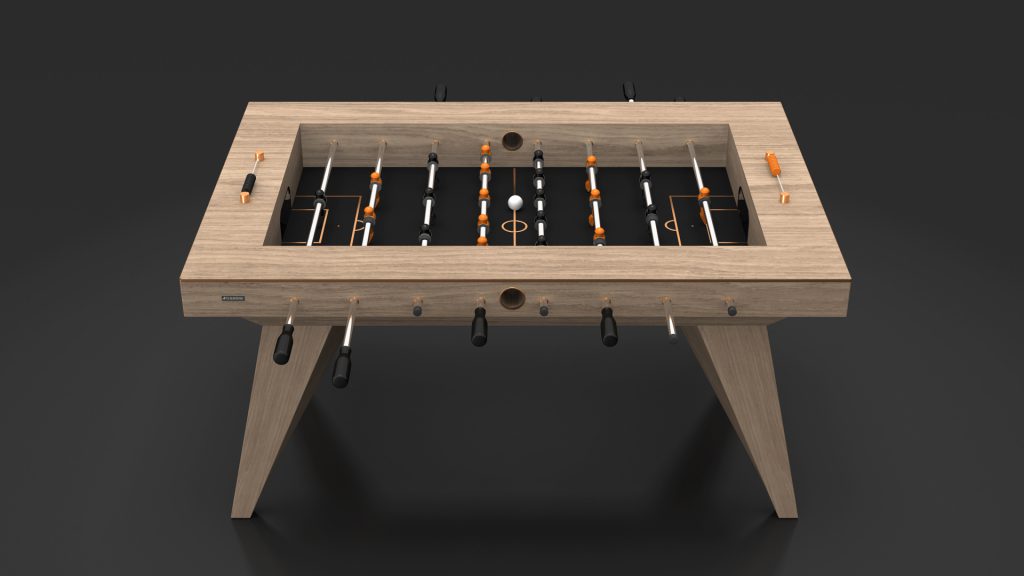 The Trigon Foosball Table features a sleek design with black and orange players on a green field. Its sturdy legs and handles contrast elegantly with the dark background, making it a sophisticated addition to any room and ideal for intense competition.