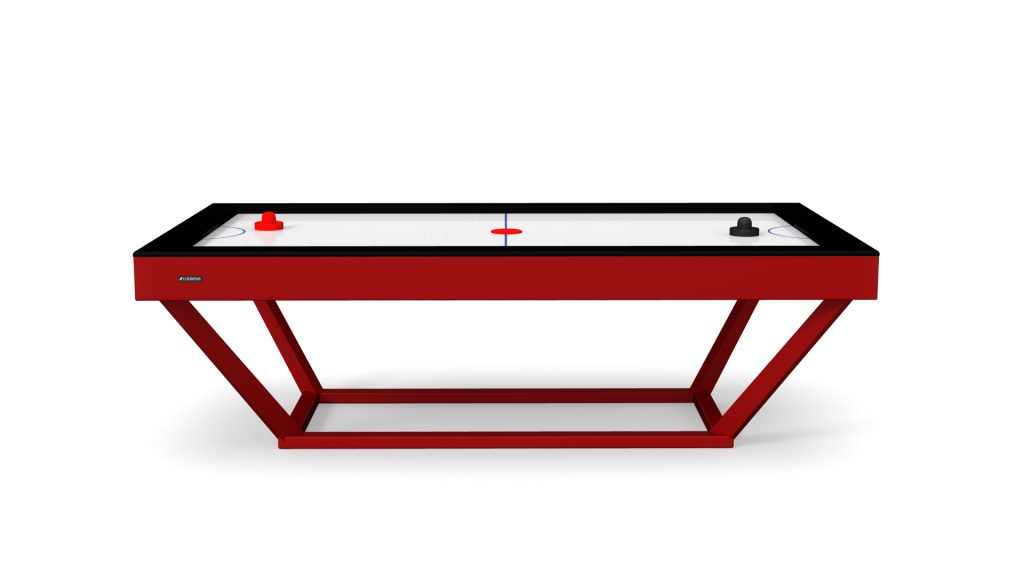 The Vitro Air Hockey Table features a sleek red design with black framing, supported by a minimalist angled base. Its glossy white surface is complete with red and black pucks and mallets, combining style and sophistication.