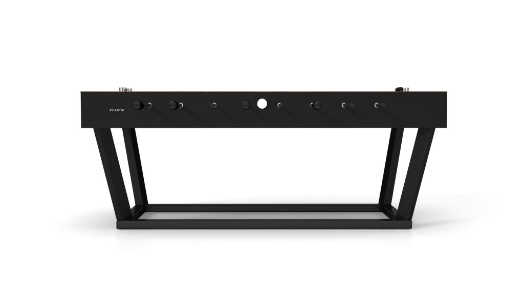 A sleek, black rectangular electronic device with knobs and buttons sits on a minimalist stand with angled legs, capturing the modern elegance of a luxury Vitro Foosball Table.
