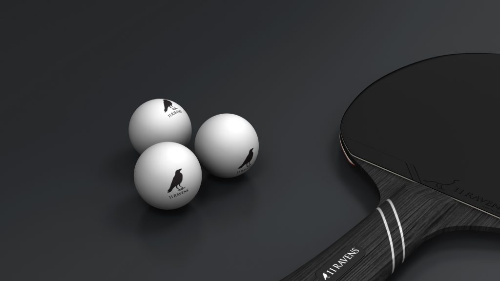 A table tennis paddle with a black handle lies next to three exquisite 11R T-T Balls, each featuring a black raven logo and 11 RAVENS text, elegantly arranged on a dark, smooth surface.