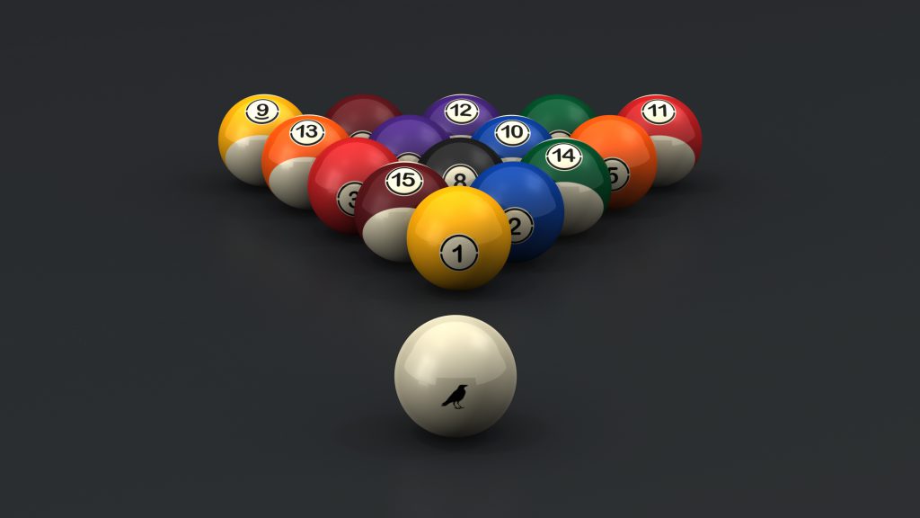 The 11R Pool Balls, a set of luxury billiard balls, are brightly colored and numbered, arranged in a triangle on a dark surface. A solid white cue ball, featuring a small black bird silhouette, is positioned in front ready for play.