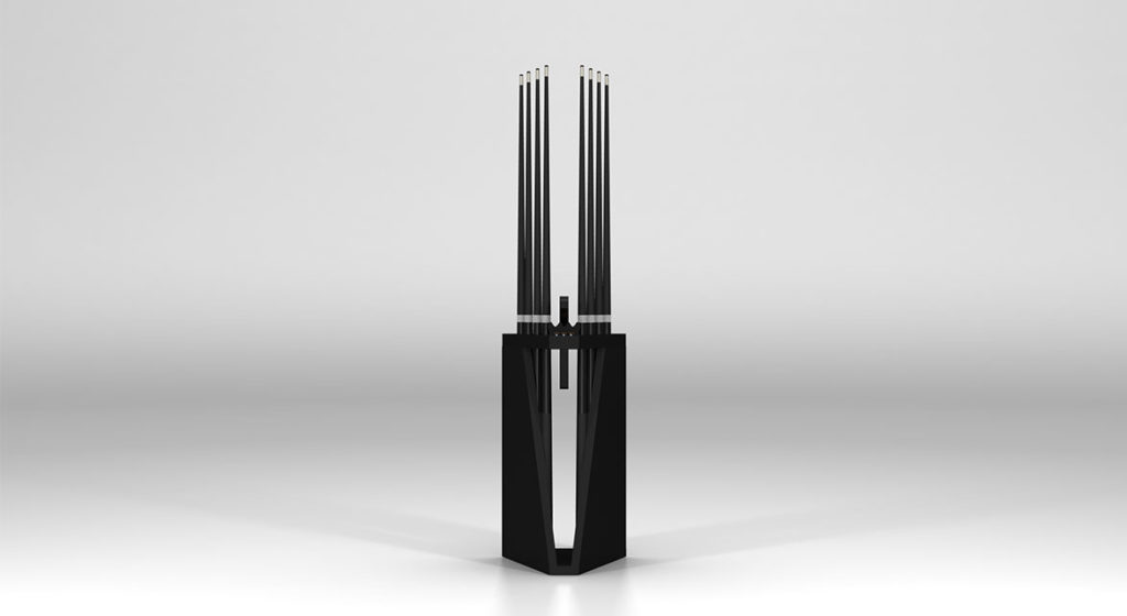 The Spartan Cue Rack - Quick Ship is a modern, abstract sculpture with a tall black rectangular base and slender, evenly spaced vertical rods that stand out boldly against a light gray background.