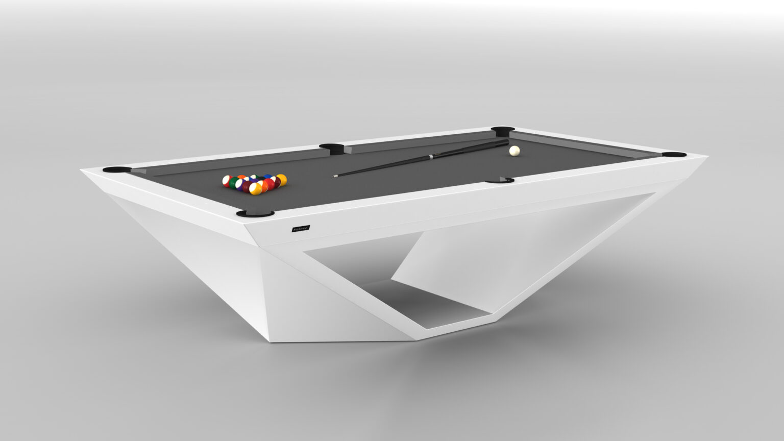 The Stealth Pool Table showcases luxury with its modern design, featuring a sleek geometric white base and dark gray surface. A cue stick and set of colored billiard balls are artfully arranged against a plain light gray background.