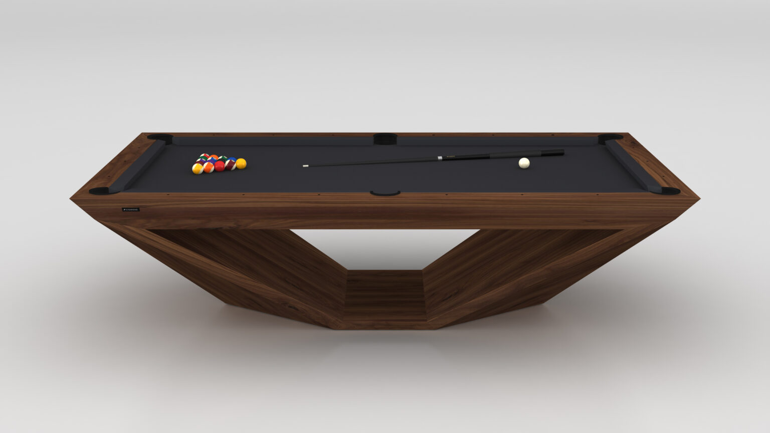 The Stealth Pool Table is a modern, minimalist luxury game table with a unique geometric wooden base and dark playing surface. It includes a cue stick, white ball, and colorful balls arranged in a triangle at one end.
