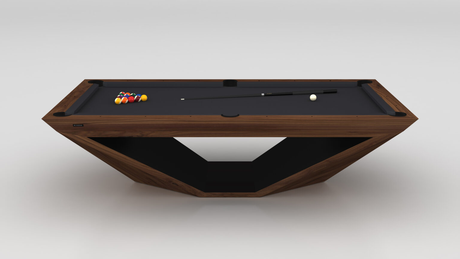 The Stealth Pool Table is a luxury game table with a modern angular design, featuring a wooden frame, black felt surface, and unique geometric base. It comes with a cue stick and vibrant ball triangle neatly arranged on this striking piece.