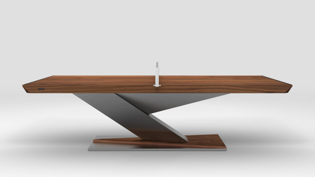 The Mitchell Ping Pong Table features a sleek, angular design with a wooden top and a zig-zag metal base, evoking luxury game tables. A small decorative object adorns its center, set against a plain light gray background.