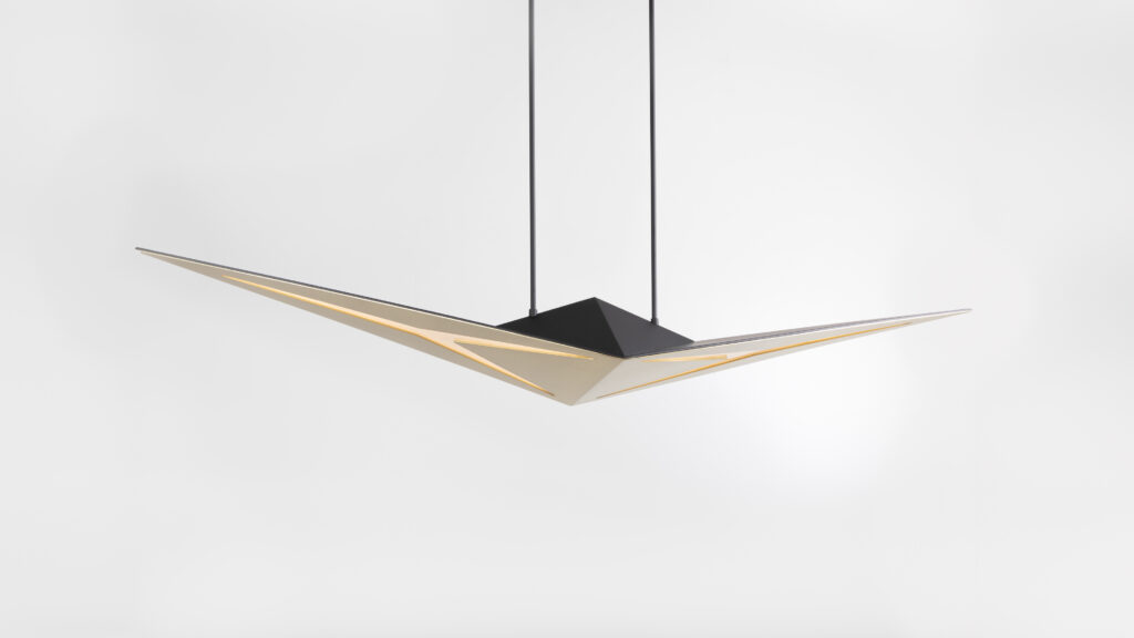 The Áves Pendant Light is a modern, triangular fixture with sharp edges and a black central mount, suspended by two cables. Its warm glow enhances its sleek geometric design, perfect for spaces with luxury game tables against a plain white backdrop.