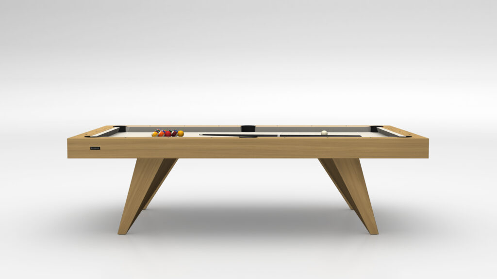 The Trigon Pool Table - Outdoor features a sleek, modern design with a light wood finish. It epitomizes luxury with its minimalist aesthetic, showcased in a bright room with neatly arranged cues and balls on the surface.
