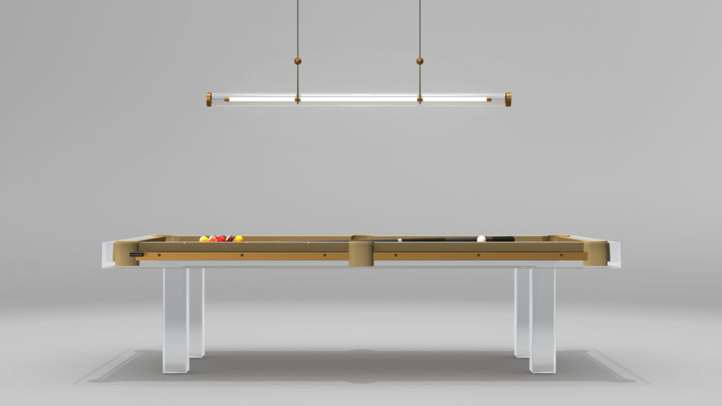 This luxe game table showcases a sleek design beneath the minimalist Cenere Pendant Light. The pool table features a beige frame and clear legs, with colorful billiard balls neatly arranged at one end against a plain gray backdrop.