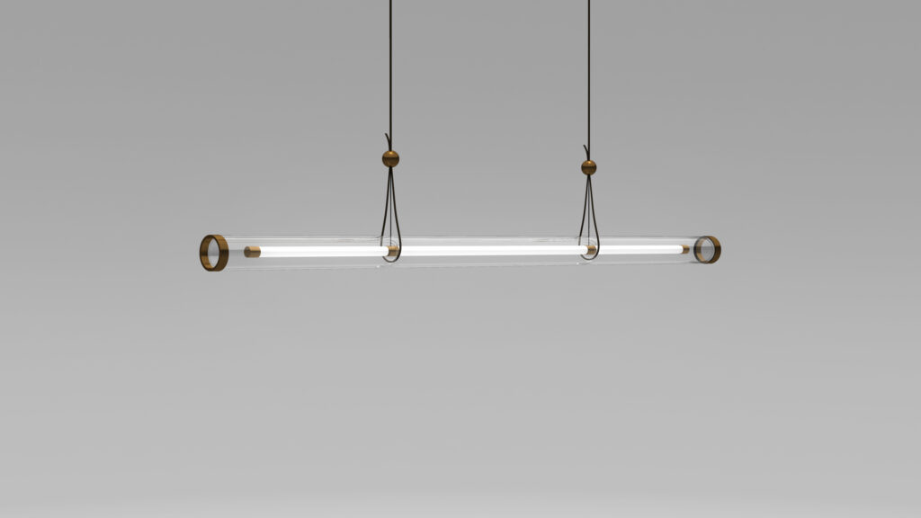 The Cenere Pendant Light, with its modern minimalist design featuring a long, transparent tube and metal accents, elegantly hangs from two cables against a plain gray background, exuding sophistication akin to spaces adorned with luxury game tables.