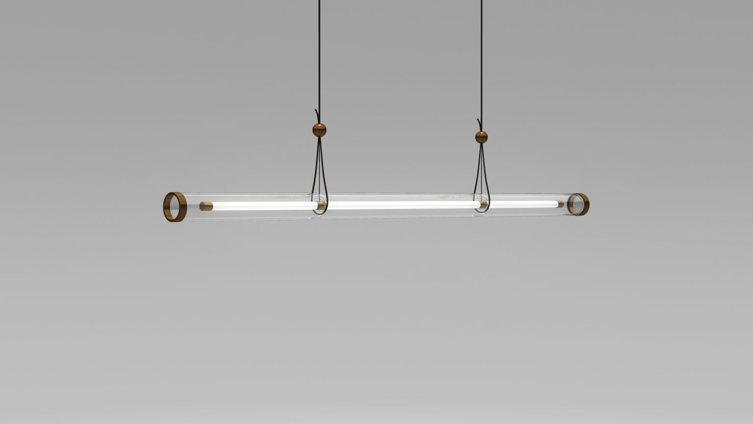 The Cenere Pendant Light, with its modern minimalist design featuring a long, transparent tube and metal accents, elegantly hangs from two cables against a plain gray background, exuding sophistication akin to spaces adorned with luxury game tables.