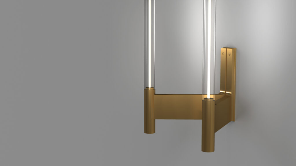 The Tré Sconce, featuring a modern, minimalist design with brass mounting and two vertical glass tubes, casts a soft glow on a gray wall, adding an elegant touch akin to luxury game tables.