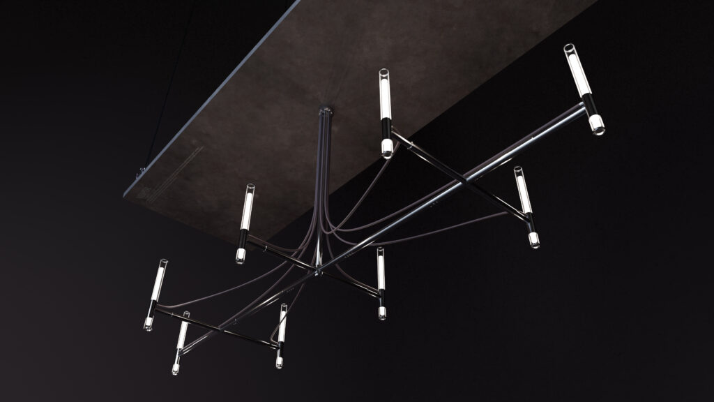 The Cena Dining Table sits beneath a modern chandelier with black metal arms and tubular LED lights, all set against a bold black background.