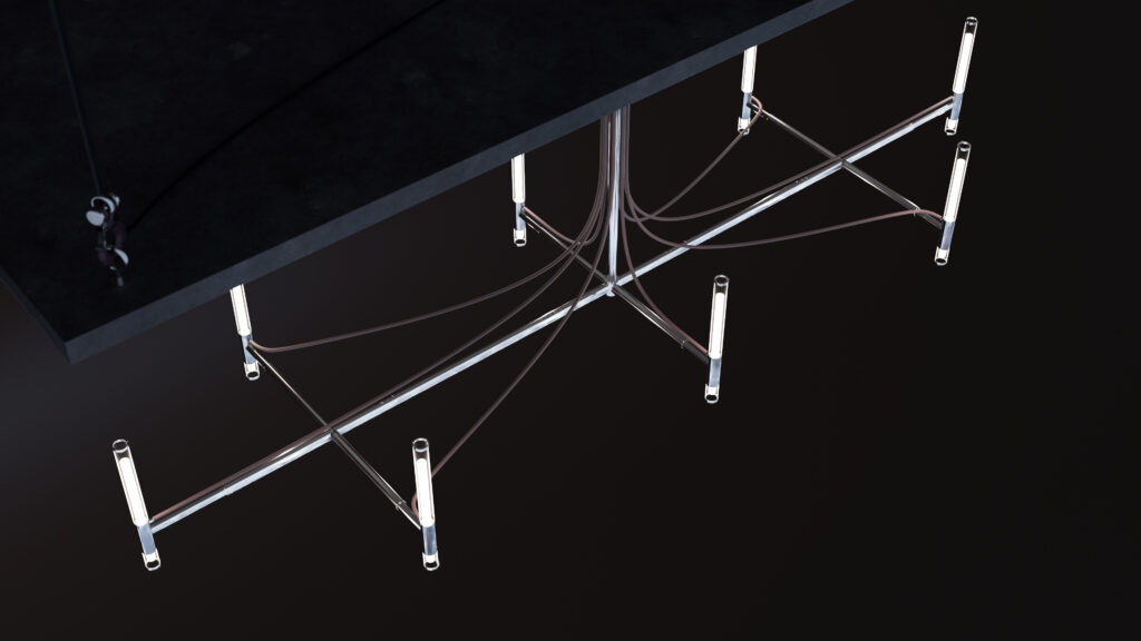 A modern, minimalist chandelier with multiple tubular lights hangs above the Cena Dining Table, suspended by metal rods and exposed wiring against a dark backdrop.