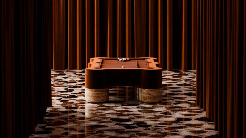 A Marc Ange Pool Table with marble legs stands on a patterned glossy floor, surrounded by tall brown curtains, with pool balls racked at one end, creating a warm and sophisticated ambiance.