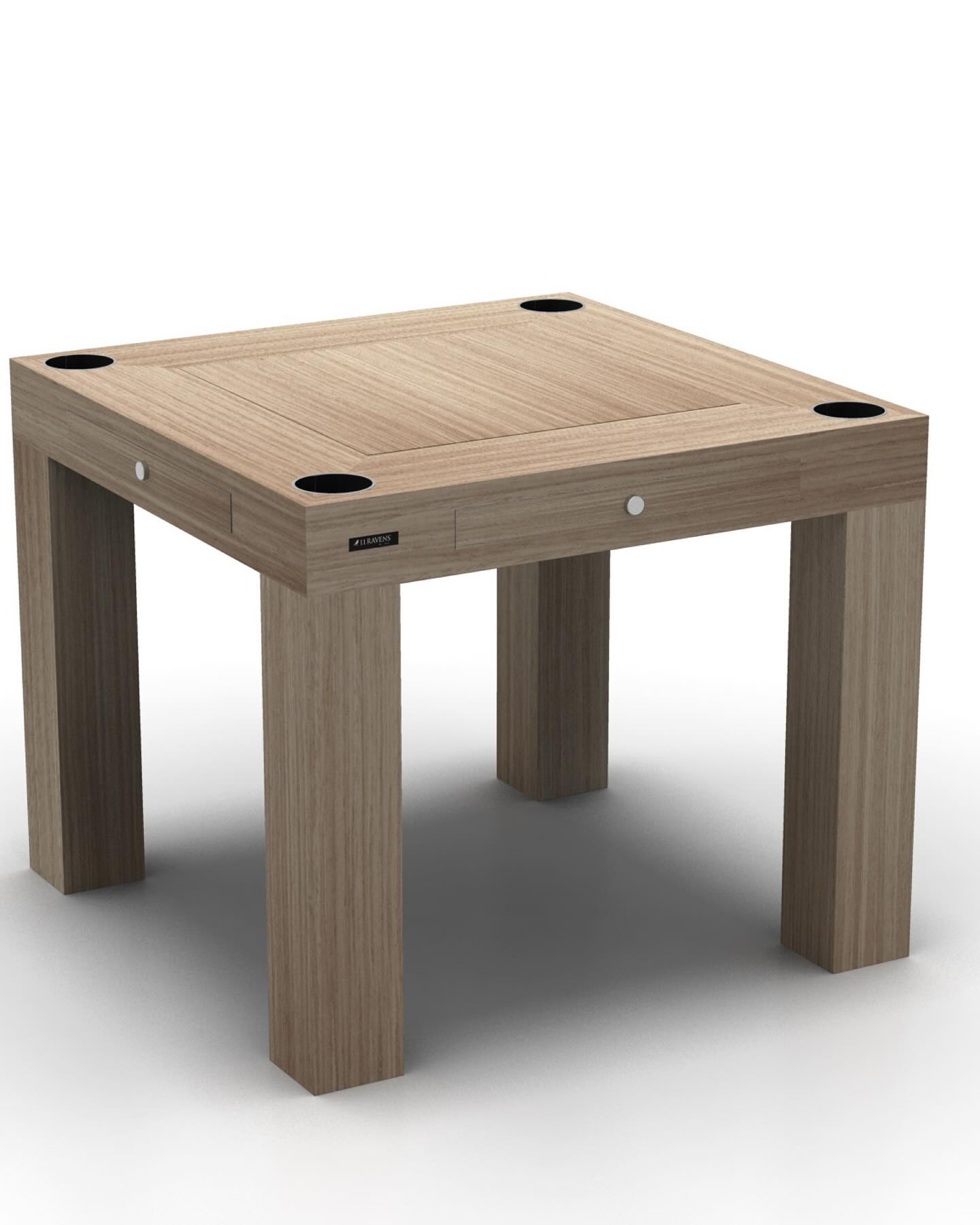 A square wooden table with a minimalist design, featuring four thick legs and black circular inserts at each corner of the tabletop.