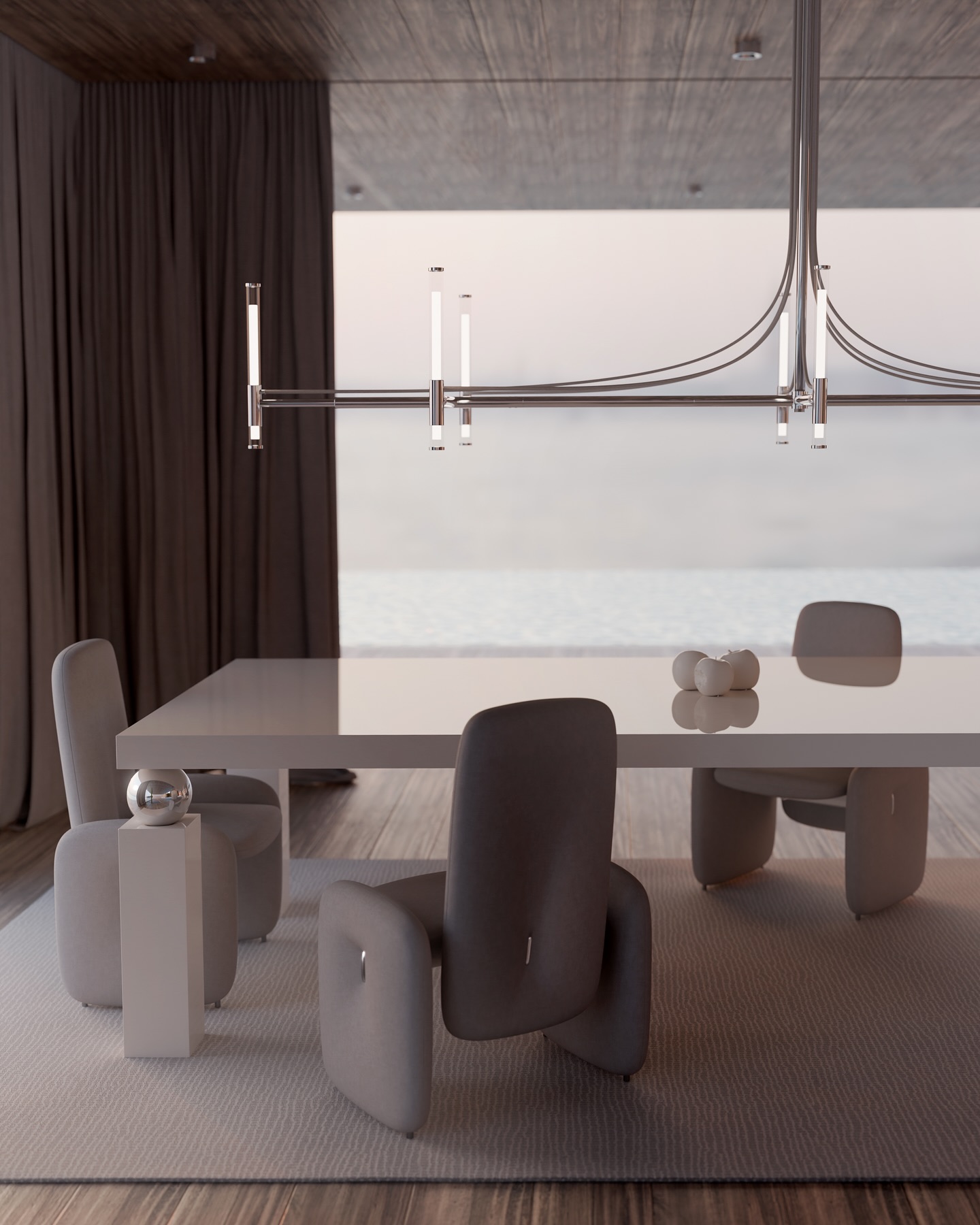 A modern dining room with a sleek white table, four gray cushioned chairs, a minimalist chandelier, and decorative spheres, set against large windows overlooking a serene water view.