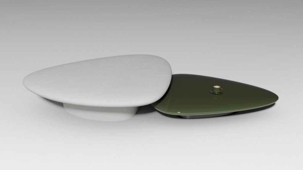 A white, smooth, stone-like object sits beside a glossy, dark green triangular device with a small gold button on top, both placed on a plain light gray surface.