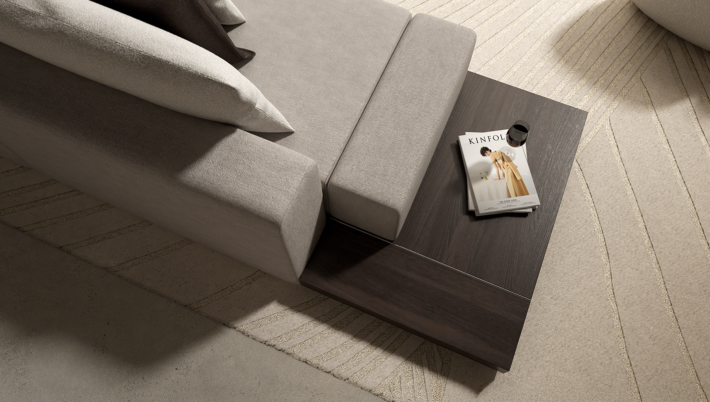 A beige sofa with white pillows sits in the living room next to a dark wooden side table holding a Kinfolk magazine and a small black object. The area rug beneath features a subtle geometric pattern, creating an inviting 11 Ravens-inspired space.