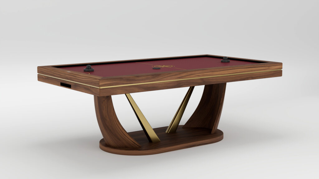 A modern handcrafted wooden air hockey table with a red playing surface, gold center design, curved legs, and two black strikers and a puck on top—luxury game tables set against a plain white background.